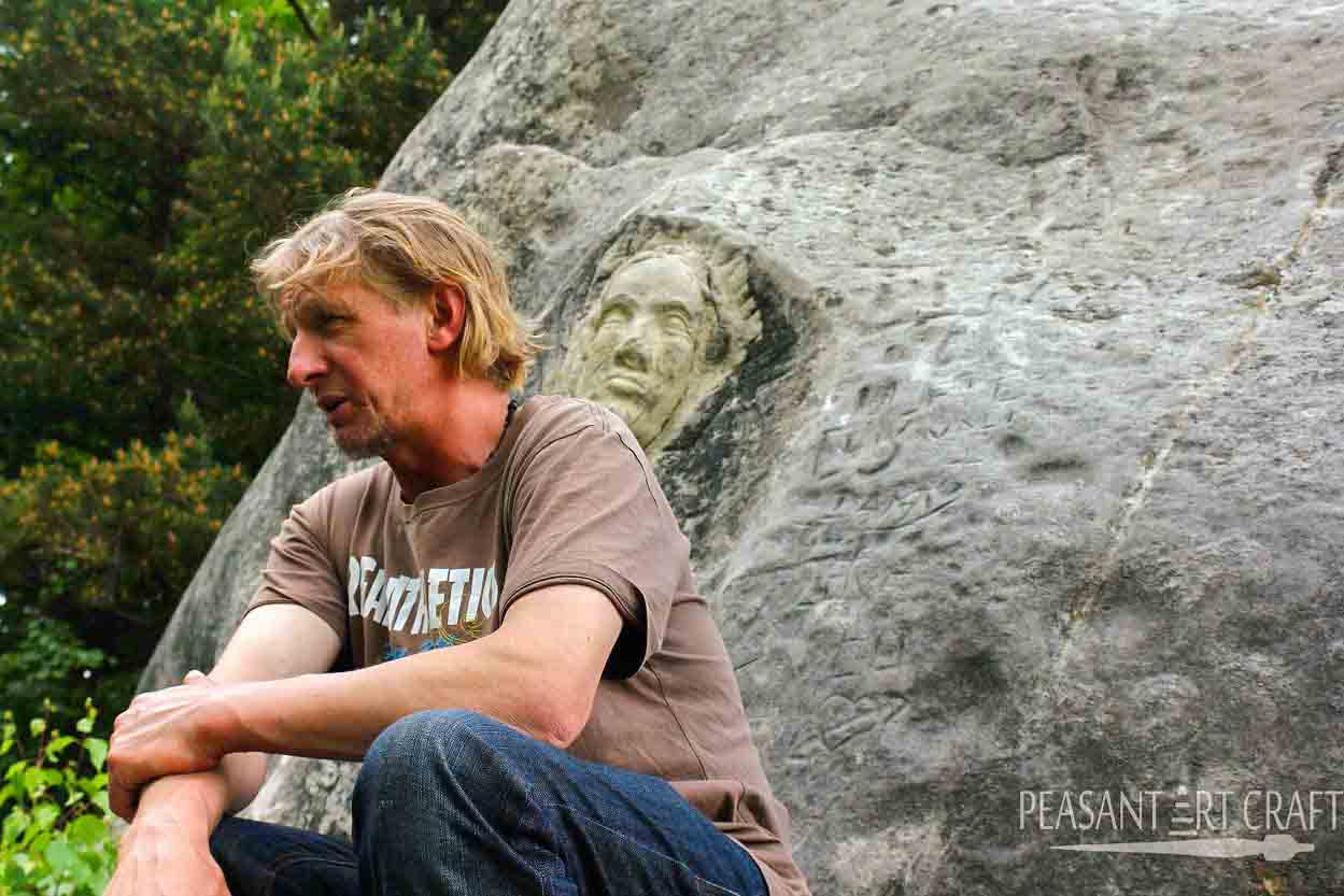 Stone Carving Ancient Faces Into Cliff